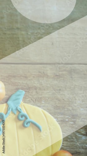 Vertical video: Sweeping bands showing teal pumpkin cookie on plank with orange spheres, copy space