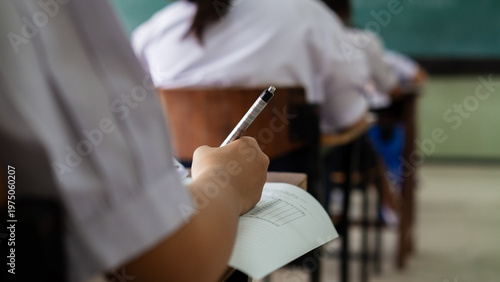 Fotografie Close-up of Student's Hand Writing on Multiple Choice Exam Paper