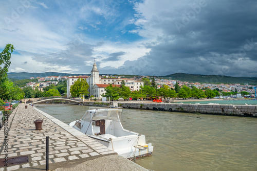 Landscape with wharf along canal and view of church in Crikvenica. Croatia