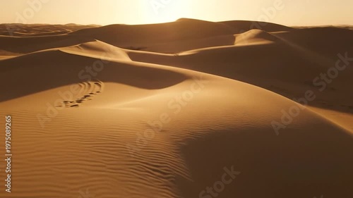 Stunning golden desert landscape with rolling sand dunes at sunrise under a clear warm sky