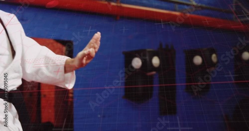 Martial-arts instructor initiating knee lift and raising arm for high palm-block kata in dojo