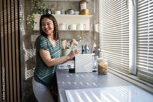 Tablou pe pânză Woman enjoying morning coffee ritual in kitchen