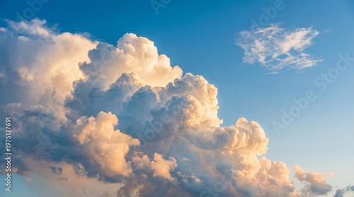 Fotografie Large white puffy clouds on a clear blue sunny sky background with a small cloud