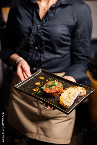 Принти на полотні Beef tartare with bread slices on elegant black serving board
Gourmet steak tart