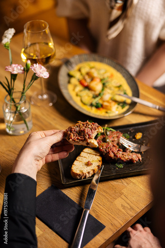 Beef tartare served on bread and being eaten
Gourmet tartare appetizer with hands close up
Fine dining tartare dish served in restaurant