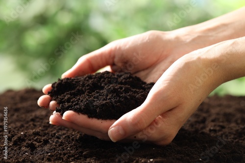 Woman with fresh soil on blurred background, closeup