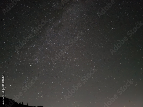 Принти на полотні Clear night sky filled with countless stars, displaying a section of the Milky Way galaxy band and the Andromeda Galaxy, Messier 31, visible as an oval smudge near the center