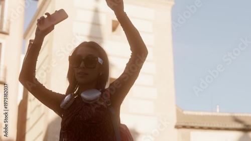 Happy young woman dancing in the city street