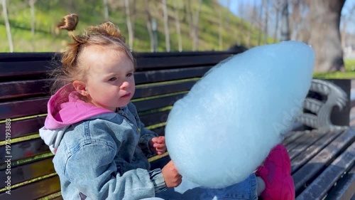 Candid close-up of a child enjoying cotton candy outdoors. Natural emotions, soft light and a relaxed lifestyle moment capturing carefree childhood and simple happiness