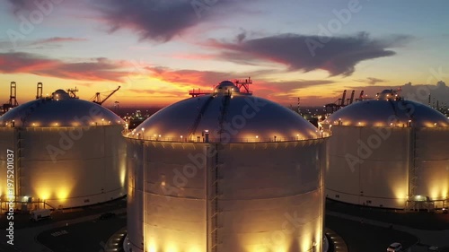 Liquefied natural gas storage tanks at industrial port during sunset aerial view
