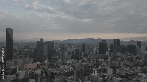 Aerial panoramic view of the Paseo de la Reforma skyline, drone flies left to right during the sunset.
