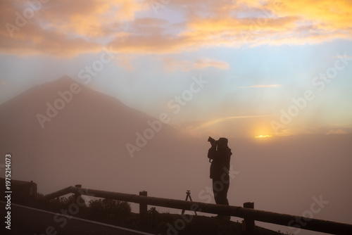 Photographer in the mountains in heavy fog, evening.