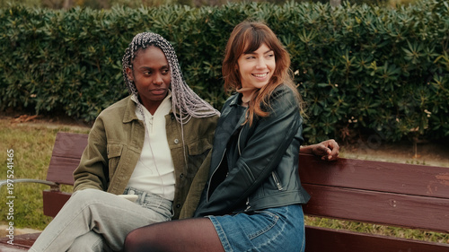 Lesbian Couple Relaxing On Park Bench Together