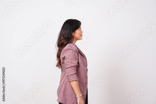 Side profile of confident businesswoman in lilac jacket standing on white background