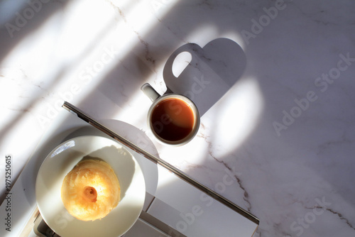 Lemon pound cake and hot coffee under sunlight and shadow on white background. Modern minimal elegant aesthetic.