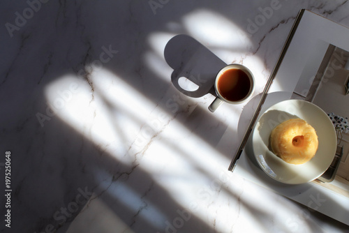 Lemon pound cake and hot coffee under sunlight and shadow on white background. Modern minimal elegant aesthetic.