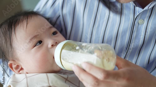 赤ちゃんにミルクを与えるお父さん