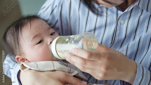 赤ちゃんにミルクを与えるお父さん