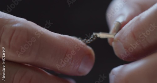 Extreme Close-up of fingers using rosary beads to pray
