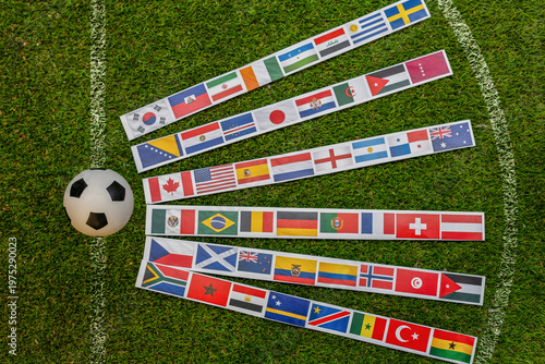 Quadro em tela Soccer ball on grass field with international flags arranged in lines