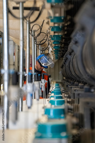 Engineers working inside a large steel pipe of a tunnel foundation. Workers involved in constructing a pipeline for transporting oil, natural gas, and fuel at an industrial factory.