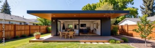 Modern backyard with a stylish open patio and sleek outdoor dining area in a sunny residential setting