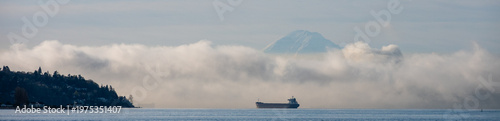 Foto Bulk carrier cargo ship in Puget Sound on a foggy morning with air full of exhaust and pollution, Mt