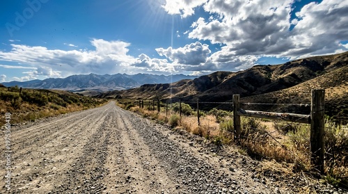 Scenic rural road through mountain landscape with rolling hills and dramatic sky