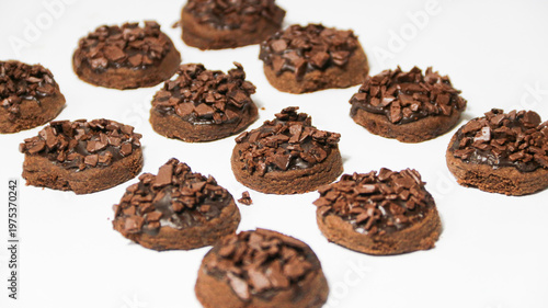 Delicious chocolate cake topped with chocolate chunks, on a white background. Freshly baked chocolate cake with a rich cocoa texture and chocolate shavings.