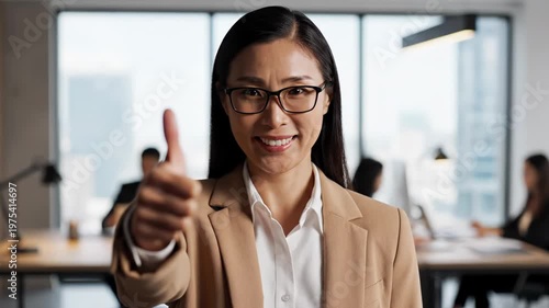 Businesswoman giving thumbs up in office.