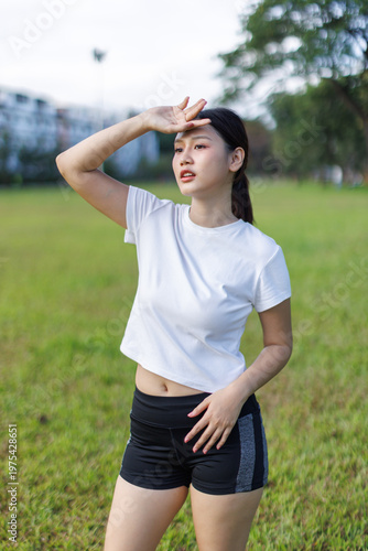 Woman shielding face from sun after outdoor workout
