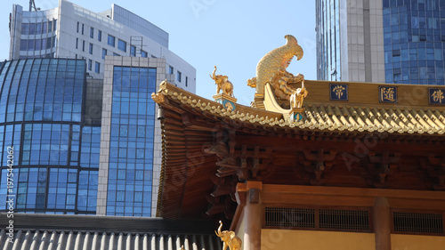 Fotografie An oriental style building with a rich, yellow facade and a traditional roof des