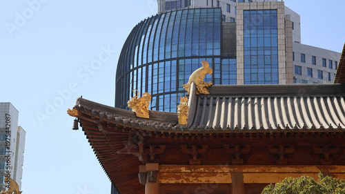 Slika na platnu An Asian style pagoda situated in front of a cityscape under a sunny sky