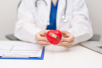 Doctor hand holding red heart shape in hospital. love, donor, world heart day, world health day, CSR donation and Insurance concepts