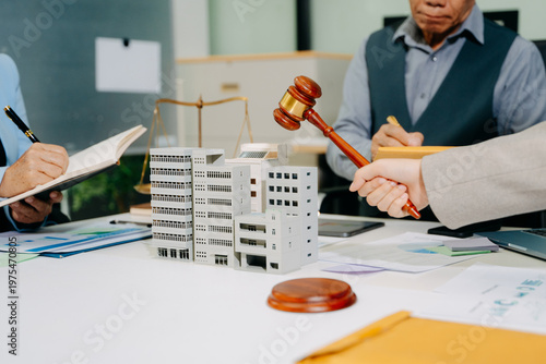 Photos Real estate legal consultation with gavel and property models, highlighting inve