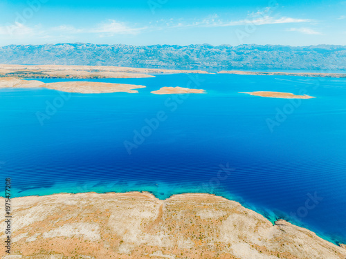 Valokuva Vrsi near Zadar archipelago cove beach in stone desert scenery near Zecevo island, Dalmatia in Croatia and Pag Island in background