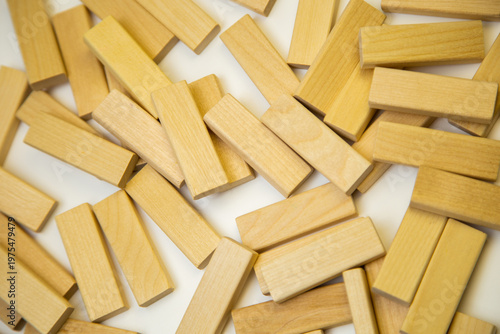 wooden bars lying in a chaotic order on a white background. Concept of wooden materials, board games, construction. High quality photo