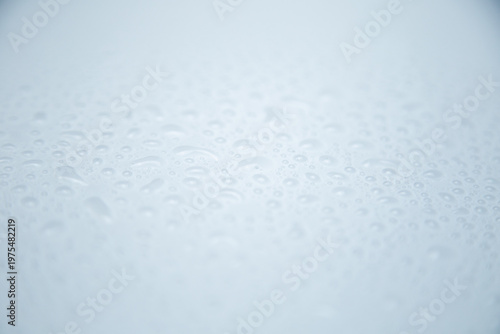 Abstract background, large water droplets with focus in the center on a white background, close-up. The concept of water, rain, humidification. High quality photo