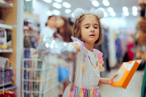 Little Girl at the Store Showing a Product to Buy It on Sale. Curious child trying to choose between two toys 