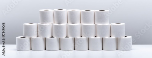 Stacked rolls of toilet paper arranged in pyramid formation on table  