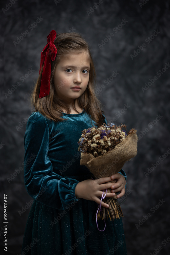 Naklejka premium Fine art portrait of a little girl in a vintage green velvet dress, holding a bouquet of dried flowers. Timeless, painterly-style studio shot with a thoughtful, nostalgic mood.
