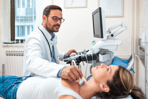 Fotografia Male doctor performing thyroid ultrasound examination on female patient in clinic