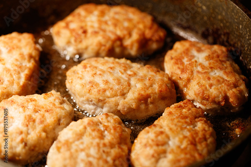 Minced meat cutlets are fried in oil in a frying pan