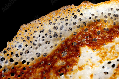 Картината върху платно Close-up of fried pancake on black background