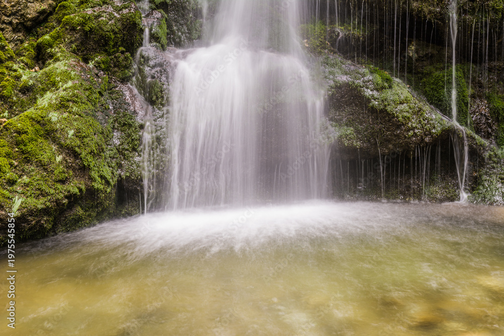 Fototapeta premium Scenic waterfall in Bavarian Alps forest with cascading water and mossy rocks close up long exposure