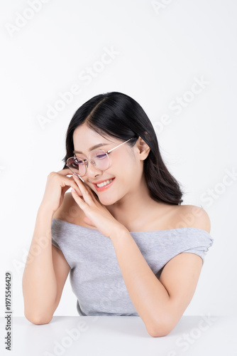 Happy asian woman wearing glasses on white background with healthy body facial skin and glowing makeup, for advertisement skincare and cosmetics concept.