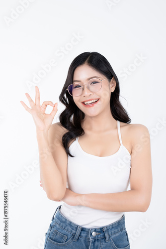 Happy asian woman wearing glasses and posture OK fingers on white background with healthy body facial skin and glowing makeup, for advertisement skincare and cosmetics concept.