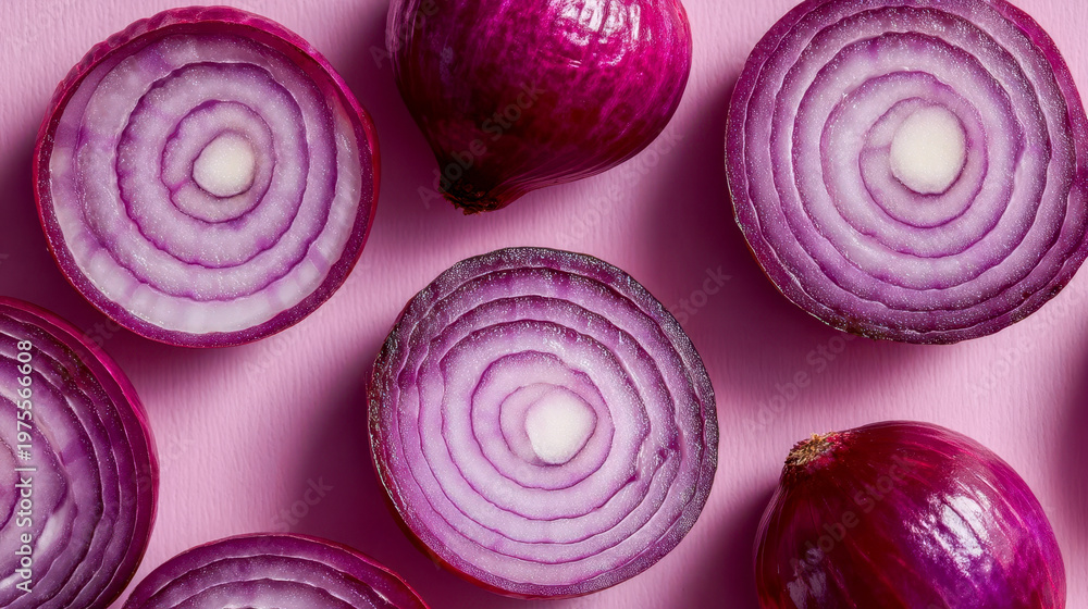 Fototapeta premium Top view of red onion halves on a pink background showing rings and whole onions