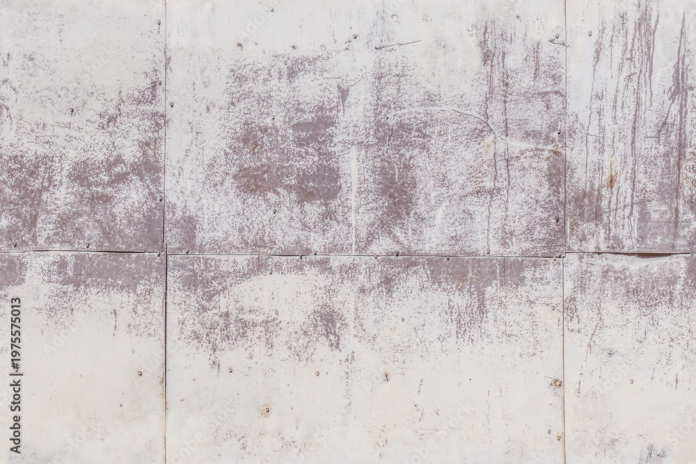 Fototapeta premium Concrete wall with faded paint and rough texture in outdoor daylight