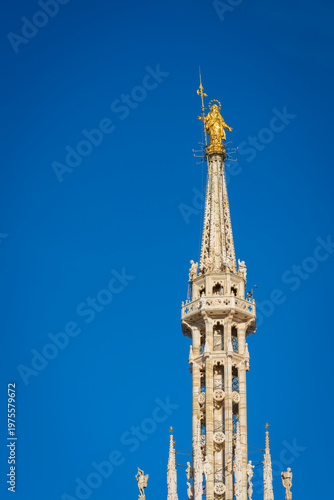 Madonnina golden statue of Virgin Mary on top of Milan Gothic Cathedral
